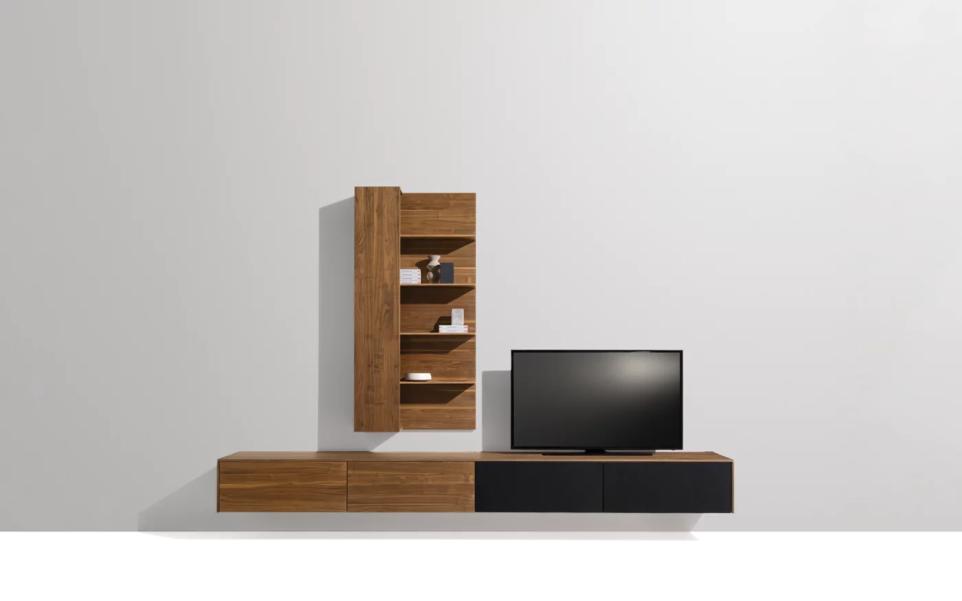 Anbauwand hängend aus Massivholz Nussbaum mit verdecktem Stauraum Moderne filigno Wohnwand aus Vollholz Nussbaum mit teilweise verdecktem Stauraum