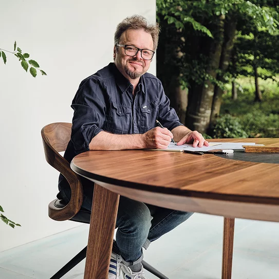Designer Sebastian Desch with the self-designed miró dining table in walnut