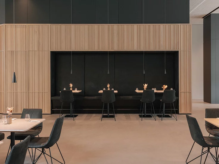 Elegant restaurant seating with bar stools and solid oak tables in the restaurant in the TEAM 7 world Elegant restaurant seating with lui bar stools and solid wood tables in natural oak oil in the restaurant in the TEAM 7 world