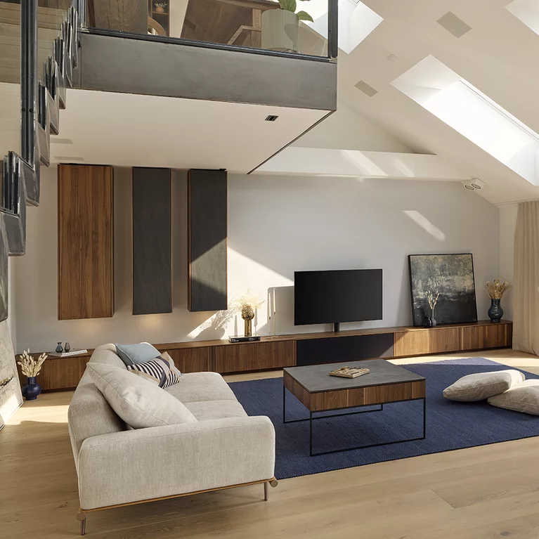 filigno Wohnwand und filigno step Couchtisch aus Nussbaum und Keramik offenes Wohnzimmer mit filigno Wohnwand und filigno step Couchtisch aus Nussbaum und Keramik