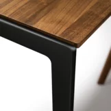 solid dining table with frame in matt black, detailed picture dining table tak made of solid wood in walnut with frame in matt black, detailed view