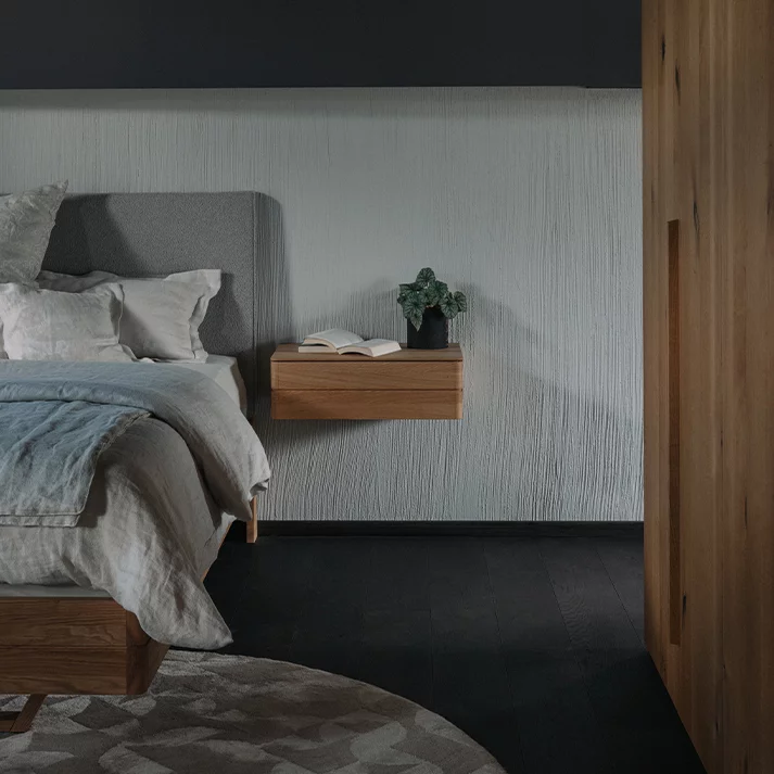 float Bett in Nussbaum mit Kopfhaupt aus Stoff mit dem float Nachtkästchen hängend